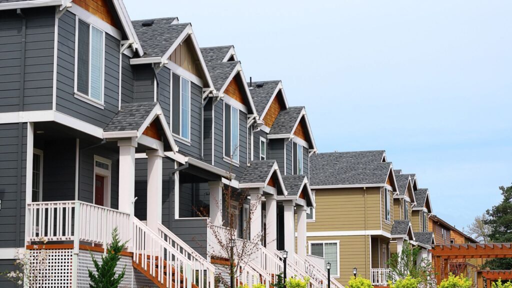 Row of houses California real estate with balconies and gray and tan walls.