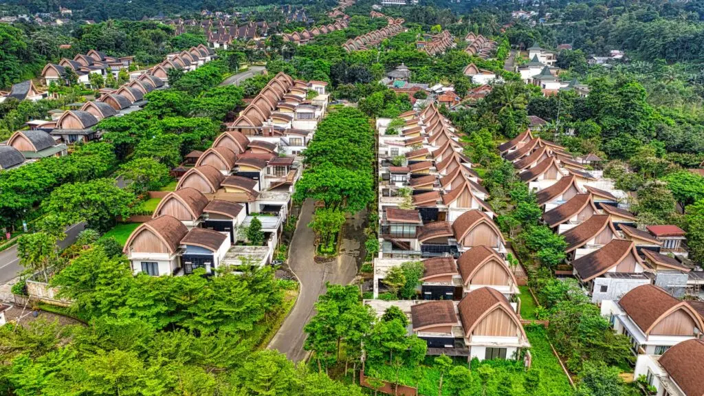 Aerial view of houses California real estate with green trees and roads around.