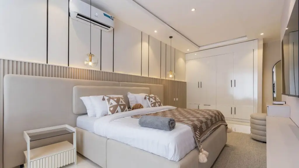 Bedroom with a big bed, pillows, air conditioner, and nice furniture.