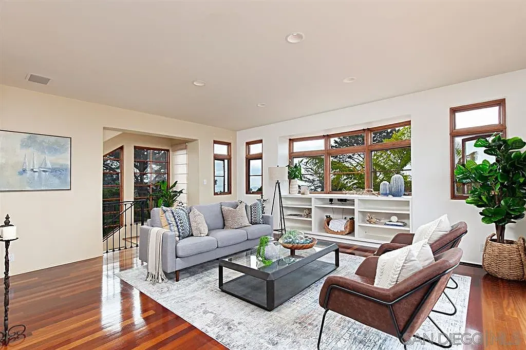Spacious living room with white sofas and expansive windows at 1135 Barcelona Drive