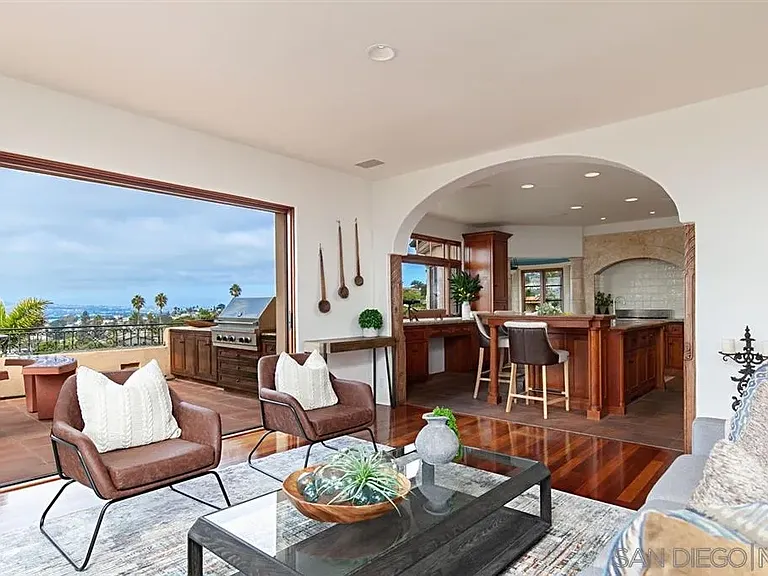 Elegant living and dining area with arched windows and coastal views at 1135 Barcelona Drive