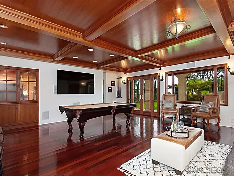 Spacious Mediterranean-style living room with exposed wood beams and fireplace