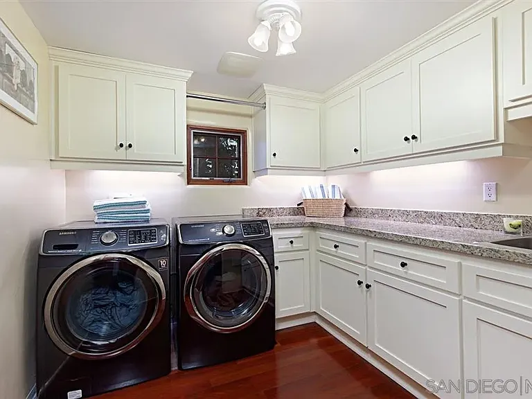 Spacious laundry room with white cabinetry and washer and dryer