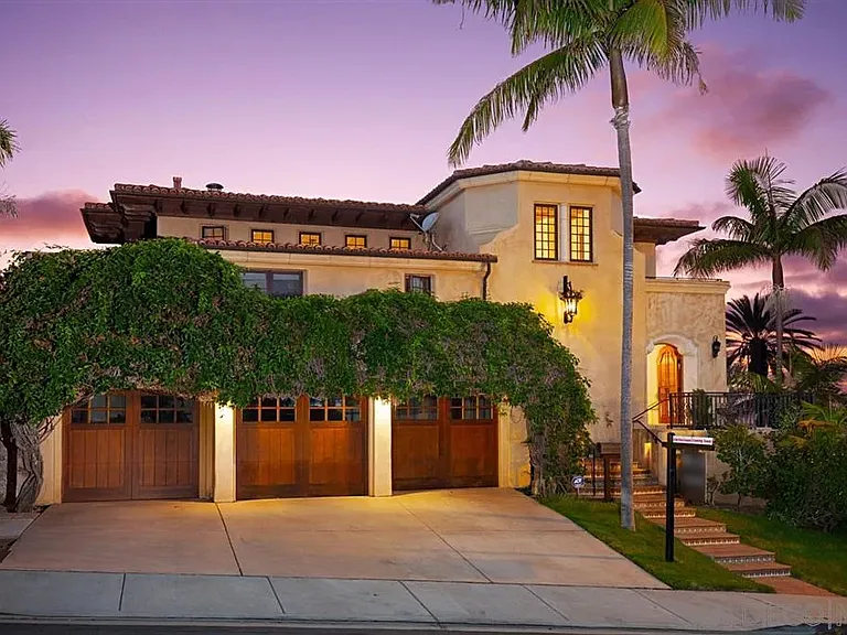 Mediterranean-style residence illuminated at sunset with landscaped exterior