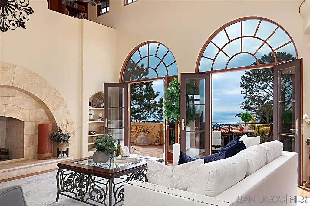 Mediterranean-style living room with arched windows and outdoor terrace access