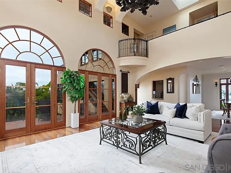 Luxury living room with soaring ceilings and arched glass doors at 1135 Barcelona Drive