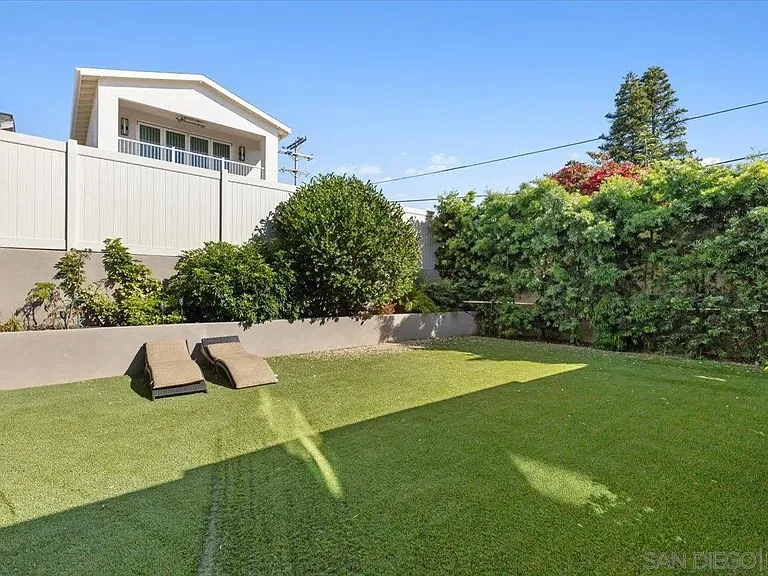 Landscaped backyard with grassy lawn and mature trees at 4515 Tivoli Street