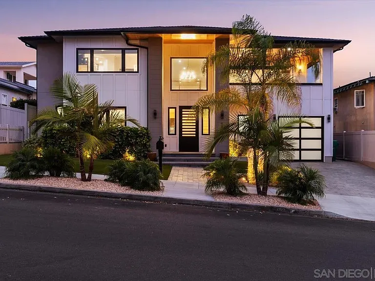 Modern San Diego home exterior with architectural lighting and landscaped entrance