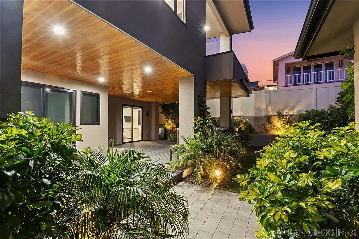 Landscaped outdoor entertainment area with wood-paneled covered patio