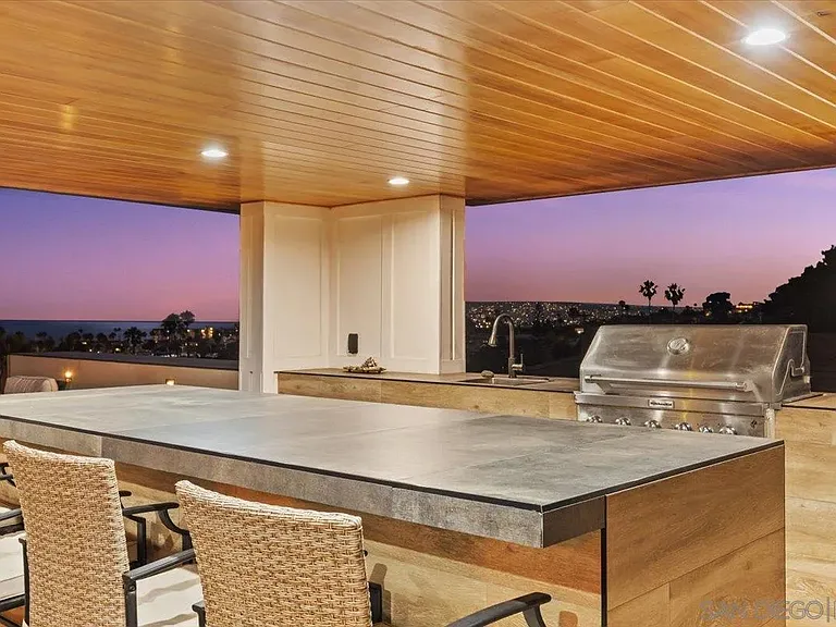 Outdoor kitchen beneath a wood-paneled covered terrace at 4515 Tivoli Street